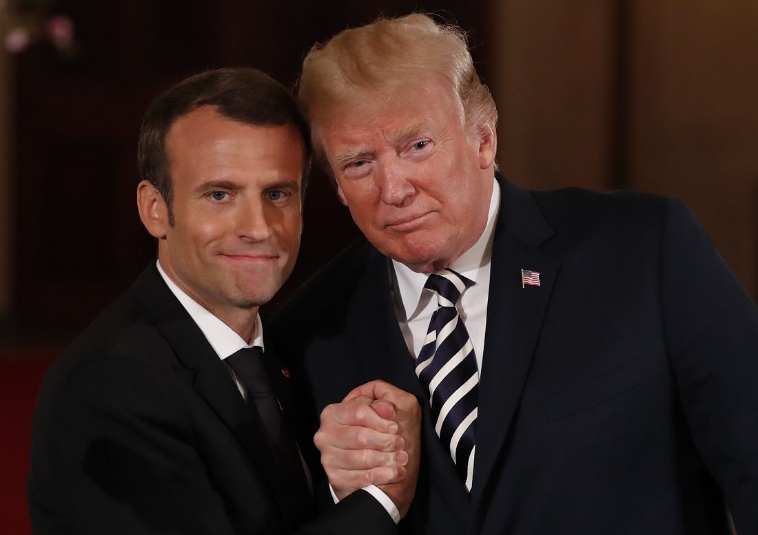 French President Macron clasps hands with U.S. President Trump at the conclusion of their joint news conference at the White House in Washington