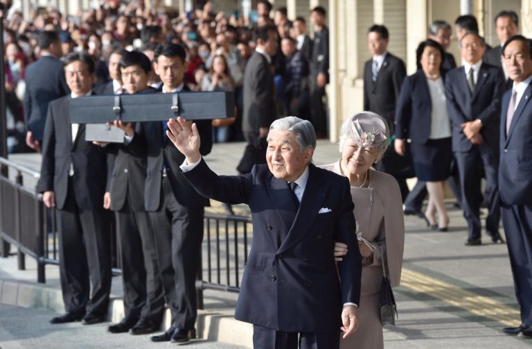 Japan's Emperor Akihito, accompanied by Empress Michiko, waves to well-wishers before leaving Ujiyamada Station after their visiting to Ise Jingu shrine in Ise