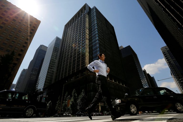 FILE PHOTO: A man runs on a crosswalk at a business district in central Tokyo