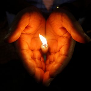 A man holds a candle during a vigil to show solidarity with the victims of Sri Lanka's serial bomb blasts, inside a college in Kolkata