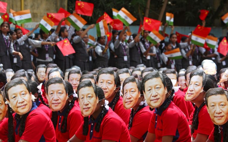 Students wear masks of China's President Xi Jinping as other waves national flags of India and China, ahead of the informal summit with India’s Prime Minister Narendra Modi, at a school in Chennai