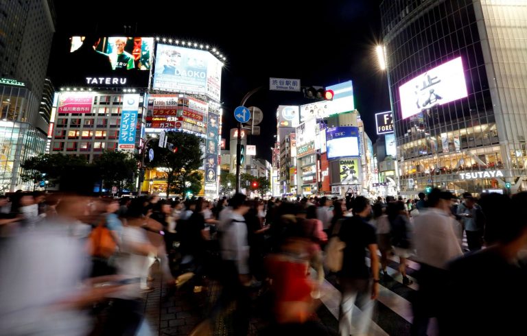 FILE PHOTO: Pedestrians walk at a scramble crossing at Shibuya shopping district in Tokyo