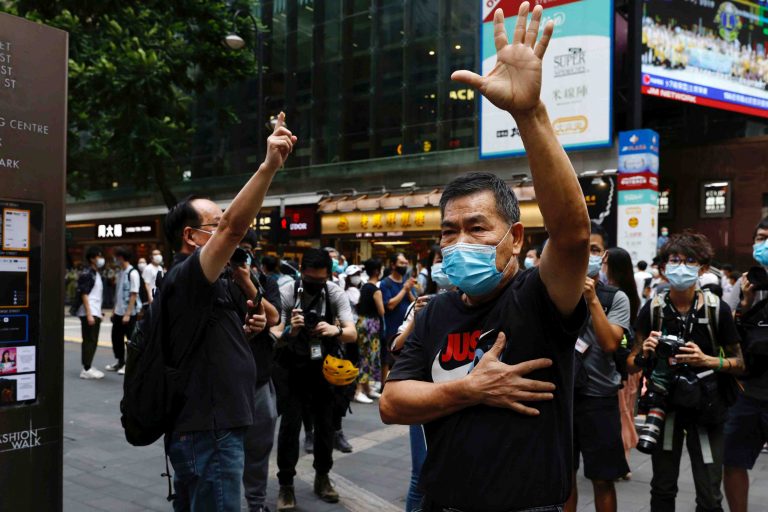 Pro-democracy protesters gesture while urging release of twelve Hong Kong activists