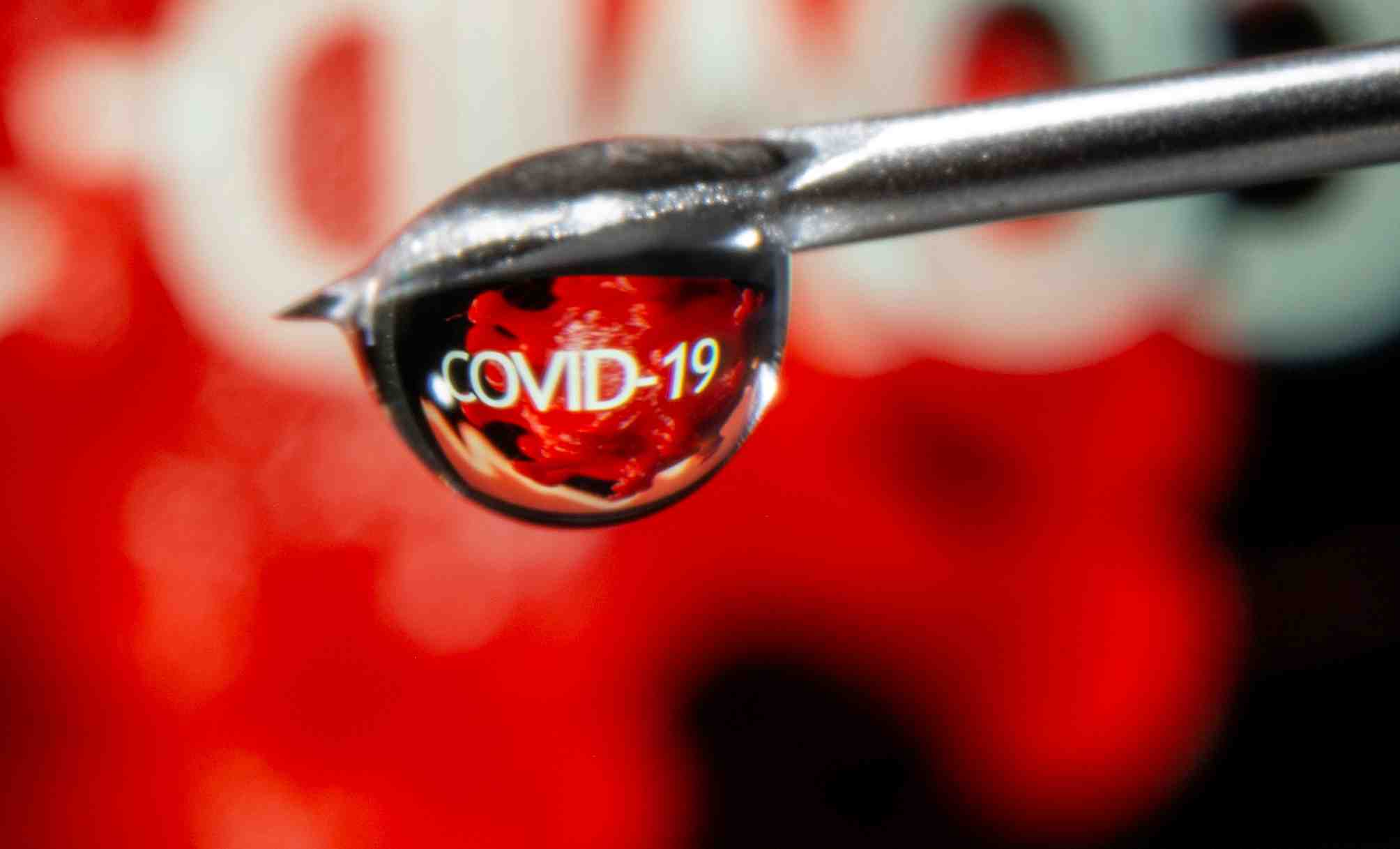 file-photo-the-word-covid-19-is-reflected-in-a-drop-on-a-syringe