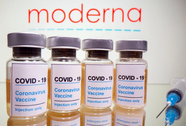 FILE PHOTO: Vials and medical syringe are seen in front of Moderna logo in this illustration