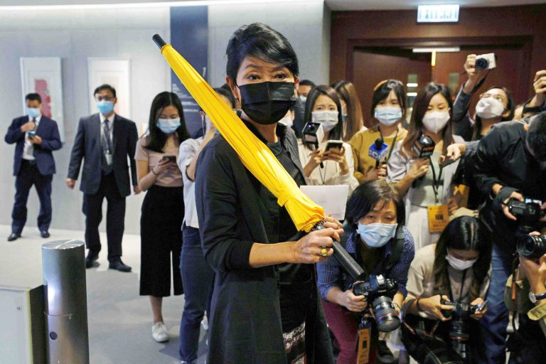 Pro-democracy legislator Claudia Mo holds a yellow umbrella, the symbol of the Occupy Central movement, and her resignation letter after four pan-democratic legislators were disqualified when China passed a new resolution in Hong Kong, China November 12, 2020. REUTERS/Tyrone Siu