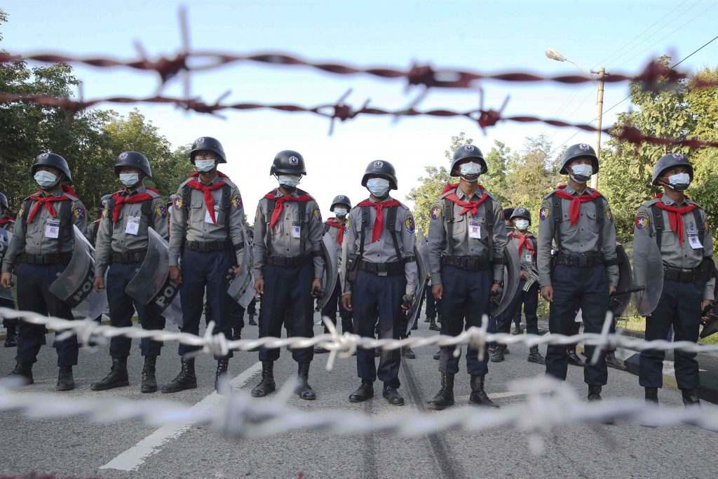 Police stand guard behind barbed wire as they attempt to stop protesters outside Union Election Commission office, Wednesday, Nov. 11, 2020, in Naypyitaw, Myanmar. The military backed main opposition party on Wednesday said it does not recognize last Sunday's Myanmar election, citing unfairness, and rejected the results. (AP Photo/Aung Shine Oo)