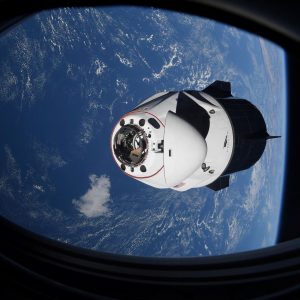 The SpaceX Crew Dragon capsule Endeavor, carrying four astronauts, approaches the International Space Station orbiting the Earth