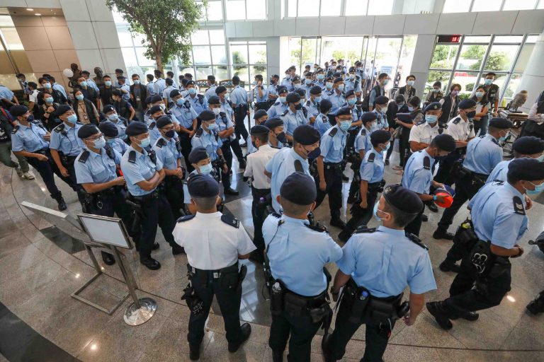 Police officers gather at the headquarters of Apple Daily in Hong Kong