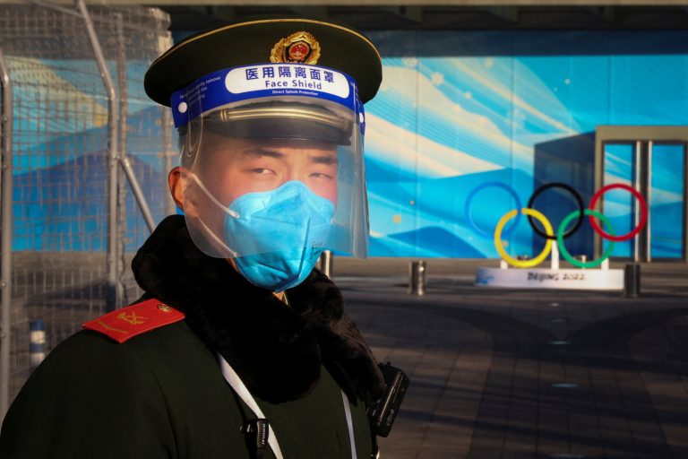 A paramilitary Police officer stands guard in front the Olympic Rings in a closed loop area near venues of the Beijing 2022 Winter Olympics in Beijing