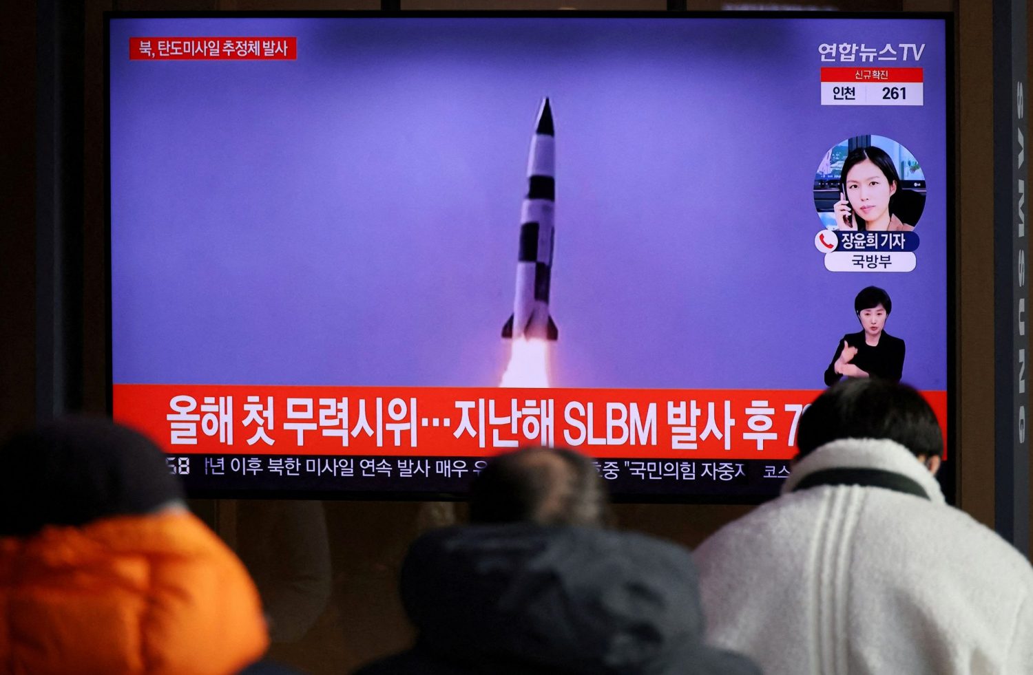 FILE PHOTO: People watch a TV broadcasting file footage of a news report on North Korea firing a ballistic missile off its east coast in Seoul